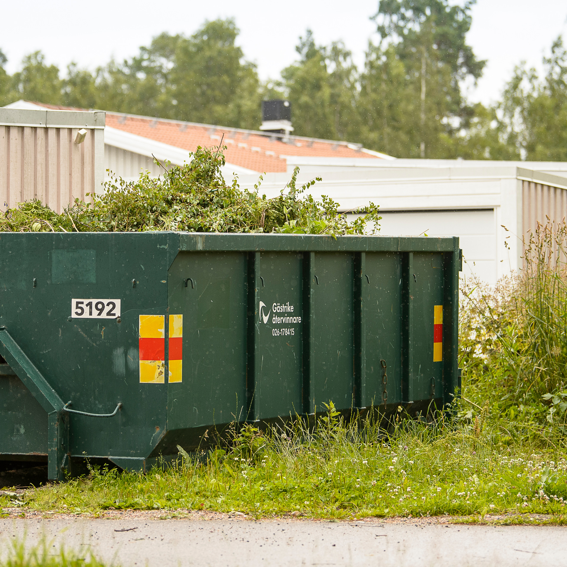 Container med trädgårdsavfall i ett bostadsområde