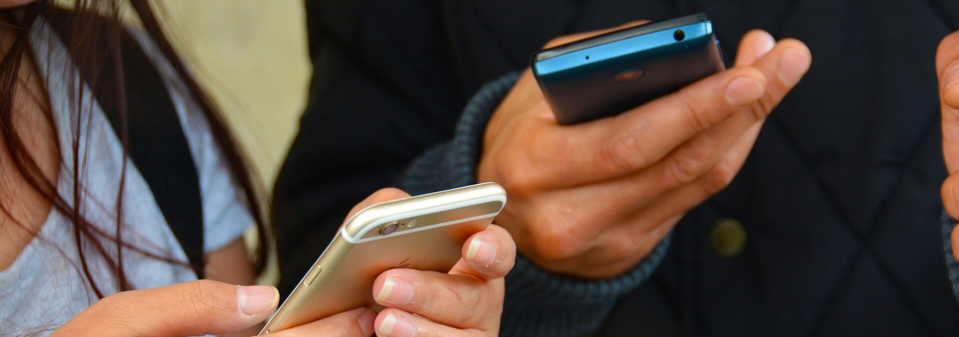 händer som håller två mobiler
