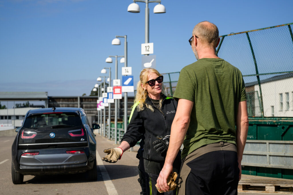 Kvinna och man i samtal vid återvinningscentral